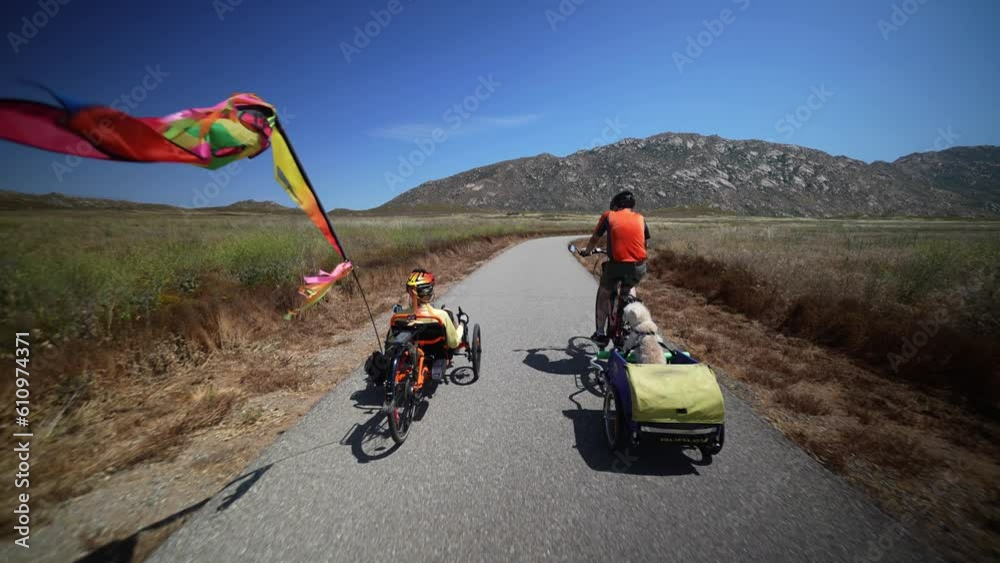 Elderly senior man on ebike biking on trail pulling a trailer with a