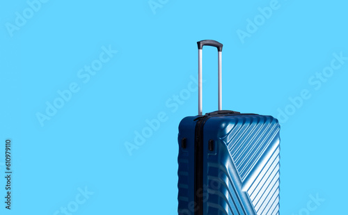 Blue colorful suitcase with handles and isolated straw sea blue background. Free space.