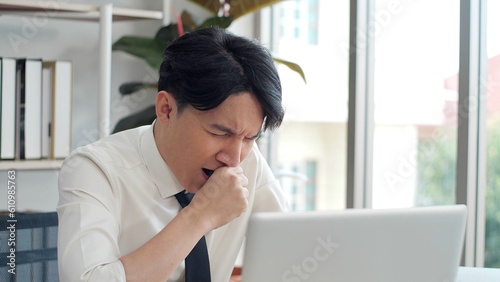 Quadro su tela Exhausted young asian worker yawning at workplace