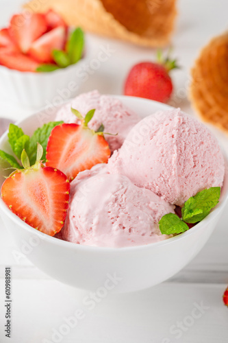Strawberry ice cream with fresh berries in a bowl on a white wooden background. Selective focus