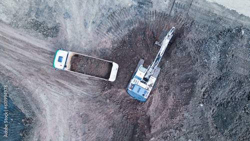 Aerial view of a construction site with excavator loading a truck 