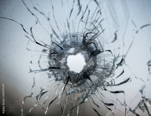 bullet hole in cracked window glass