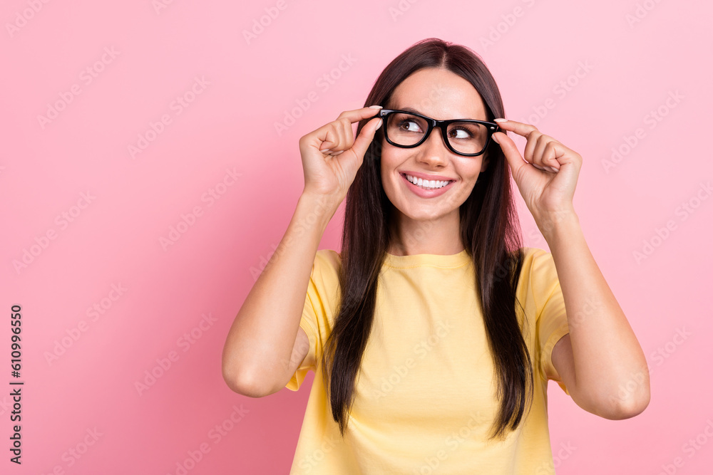 Photo of shiny dreamy woman dressed yellow t-shirt arms eyewear looking empty space isolated pink color background