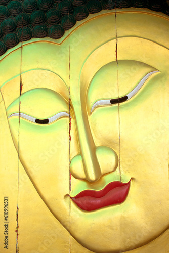 Golden Buddha image in thai style wood graving on the wall