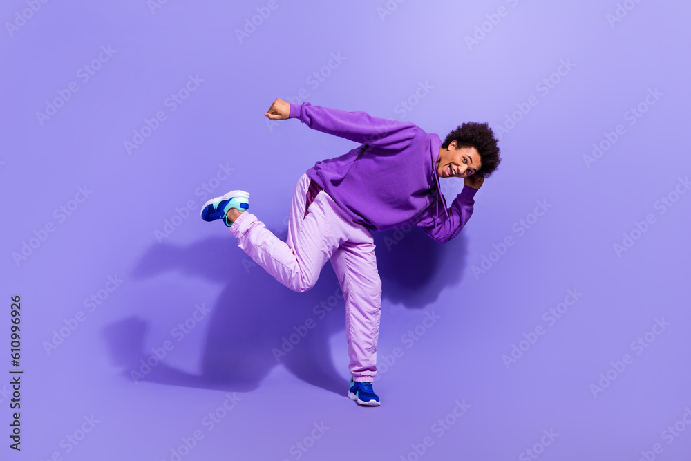 Full size photo of funny funky satisfied positive person wear violet hoodie pants dancing having fun isolated on purple color background