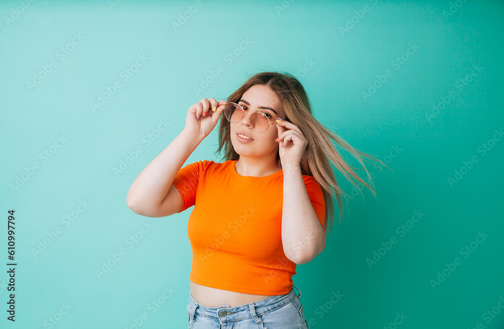 Close-up portrait of a stylish european girl in sunglasses on a blue background. summer concept. summer portrait