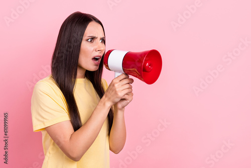 Photo of shocked angry lady wear yellow t-shirt shouting loud speaker empty space isolated pink color background