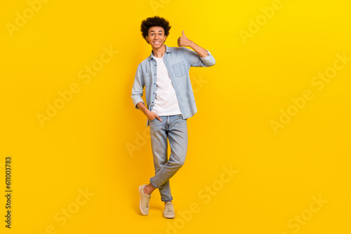 Full length portrait of satisfied person hand finger demonstrate thumb up approval isolated on yellow color background