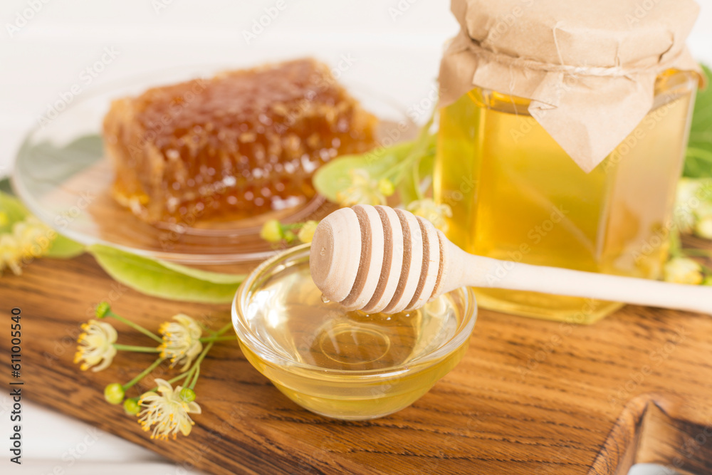 Linden honey with leaves and flowers on table Linden honey with leaves and flowers on table
