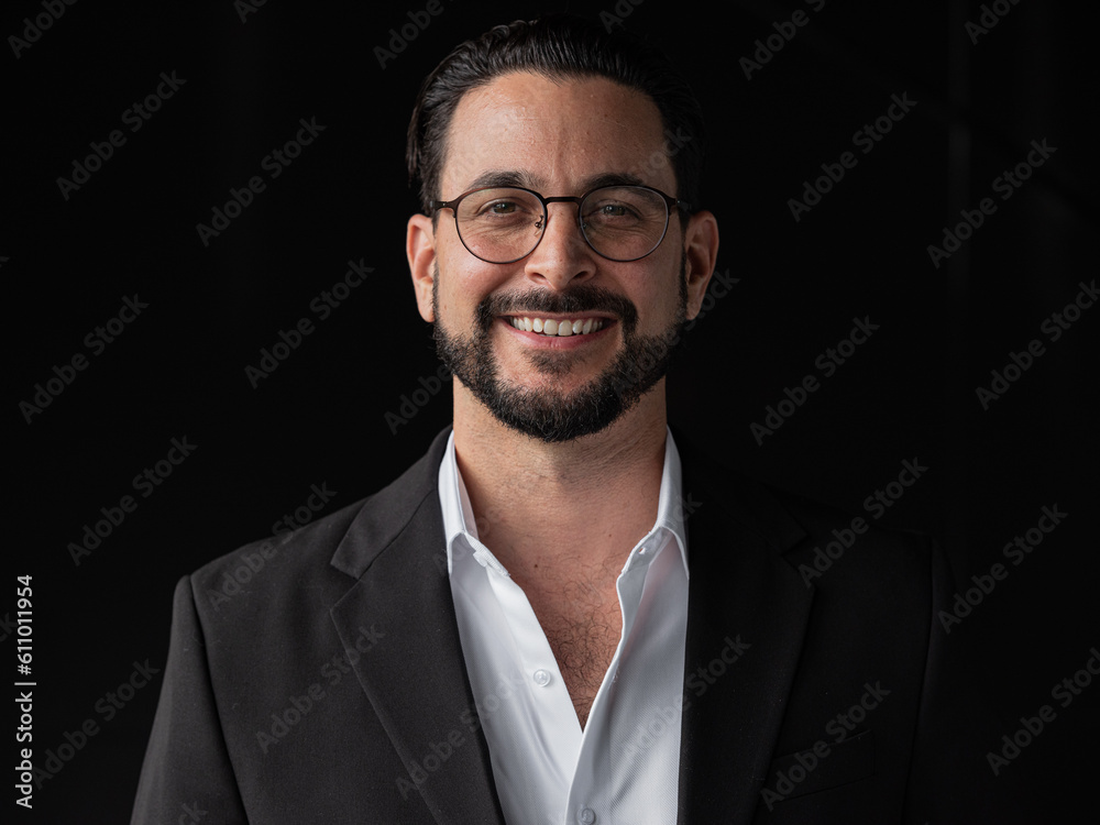 Portrait of handsome businessman against black background smiling Portrait of handsome businessman against black background smiling