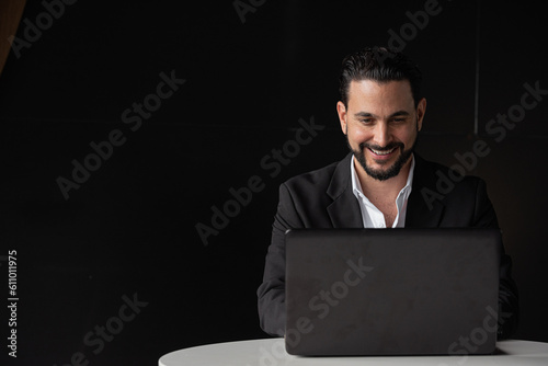 Portrait of handsome businessman using laptop computer while smiling