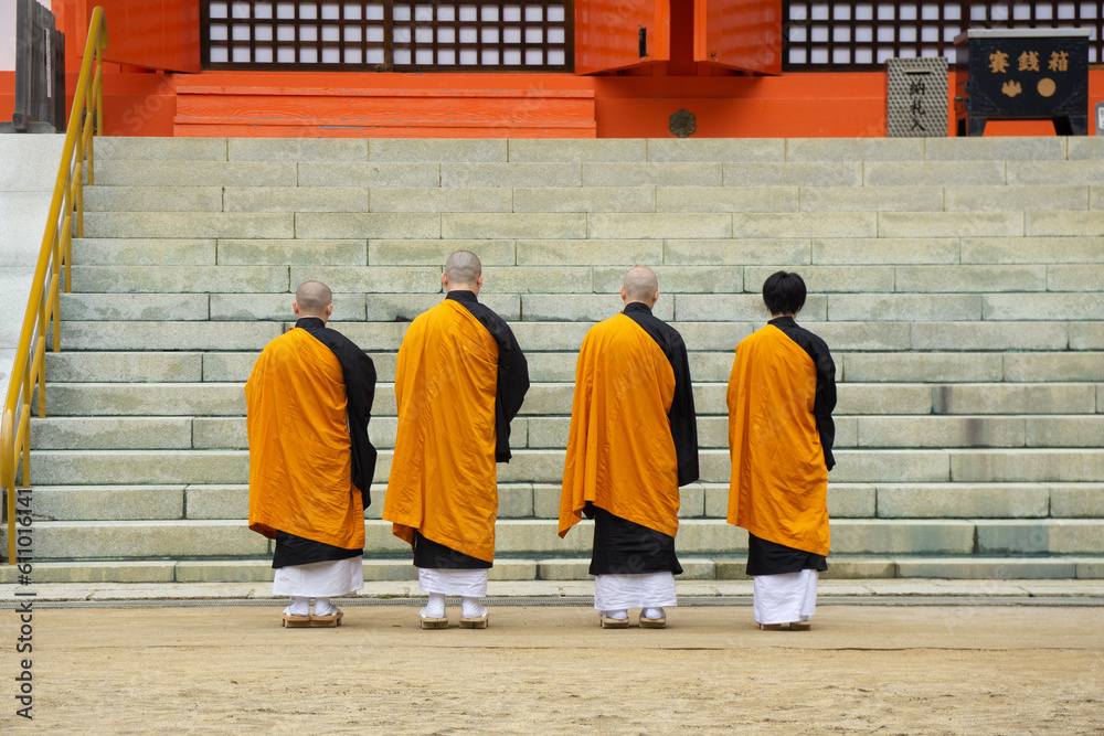 Japanese Buddhist Monks wearing traditional orange Robe stanning in