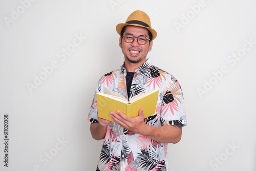 Asian tourist smiling happy while reading a book photo