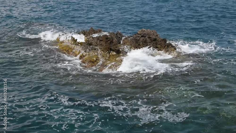 Seascape with a rock in the water and waves Seascape with a rock in the water and waves