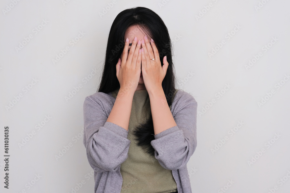 Young Asian women covering her face with both hands showing scared expression Young Asian women covering her face with both hands showing scared expression