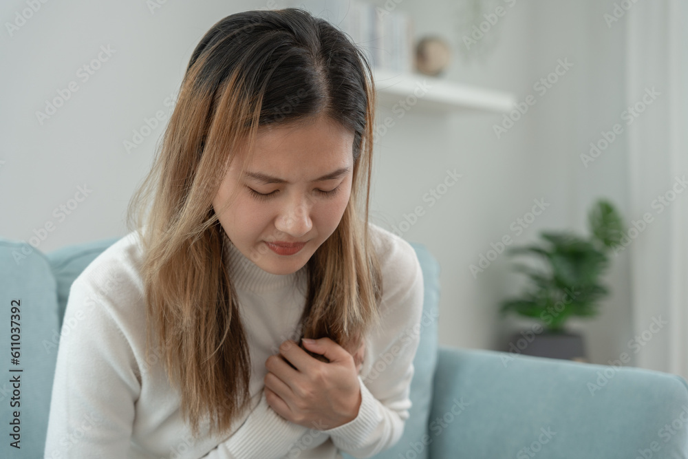 hand hold chest with heart attack symptoms, asian woman have chest pain caused by heart disease, leak, dilatation, enlarged coronary heart, press on the chest with a painful expression hand hold chest with heart attack symptoms, asian woman have chest pain caused by heart disease, leak, dilatation, enlarged coronary heart, press on the chest with a painful expression