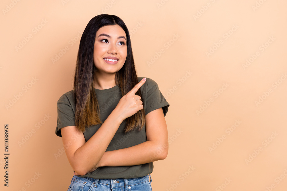 Portrait of charming wondered asian girl direct finger curious empty space novelty banner isolated beige color background Portrait of charming wondered asian girl direct finger curious empty space novelty banner isolated beige color background