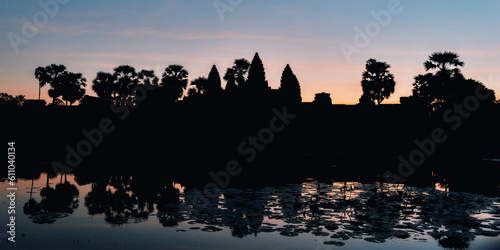 Experience the ethereal charm of Angkor Wat at dawn, where the dark sky and tree silhouettes add a touch of mystique to the Cambodian landscape.