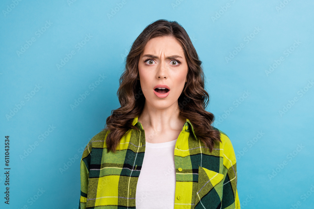 Photo of shocked crazy offended woman with curly hairdo dressed checkered shirt staring open mouth isolated on blue color background Photo of shocked crazy offended woman with curly hairdo dressed checkered shirt staring open mouth isolated on blue color background