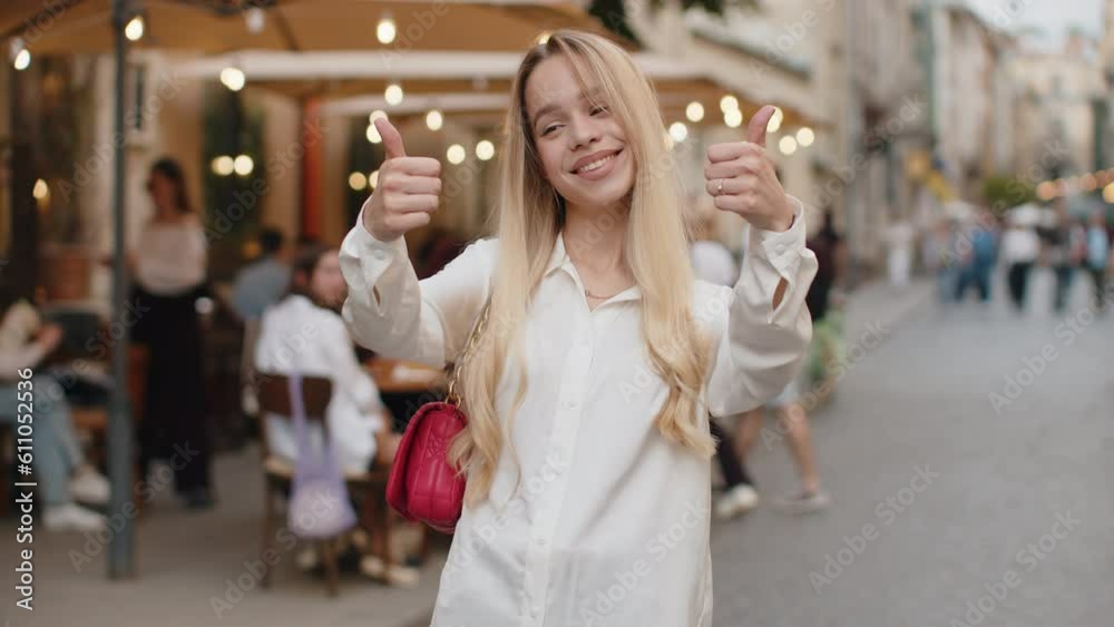 Like. Happy blonde young woman looking approvingly at camera showing thumbs up, like sign positive something good positive feedback. Teenager girl walking in urban city street. Town lifestyles outdoor Like. Happy blonde young woman looking approvingly at camera showing thumbs up, like sign positive something good positive feedback. Teenager girl walking in urban city street. Town lifestyles outdoor