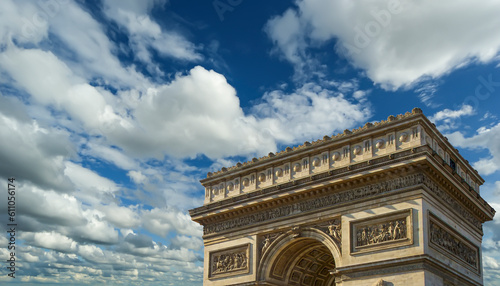 Arc de Triomphe (against the background of sky with clouds), Paris, France. The walls of the arch are engraved with the names of 128 battles and names of 660 French military leaders (in French)