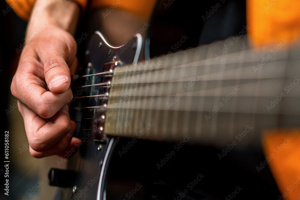 Fototapeta premium rock performer with electric guitar in recording studio recording playing own track creating song musical instrument strings close-up