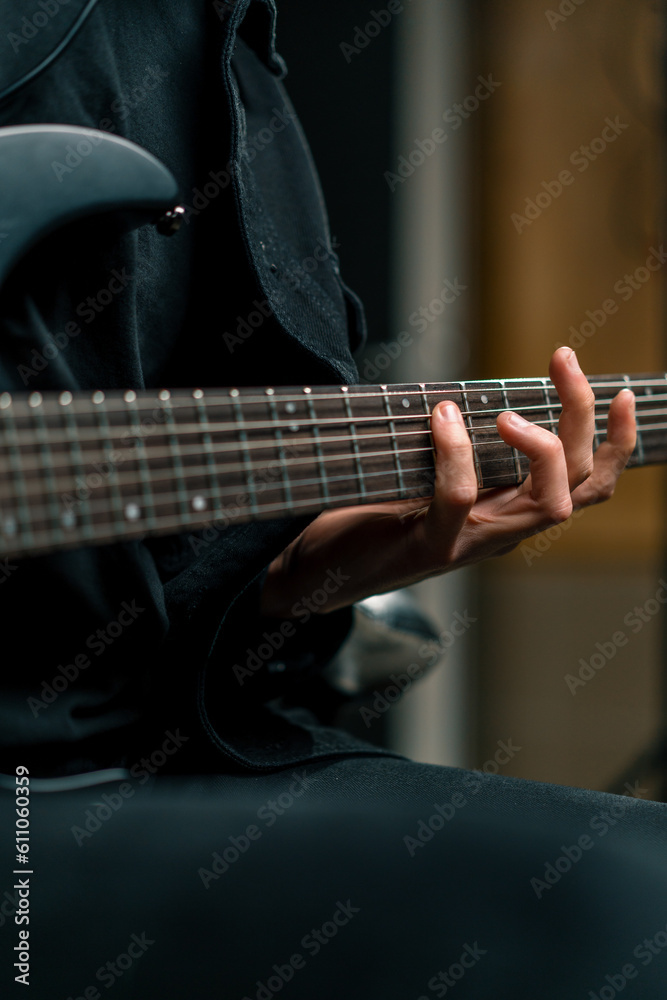 Fototapeta premium rock performer with electric guitar in recording studio recording playing own track creating song musical instrument strings close-up