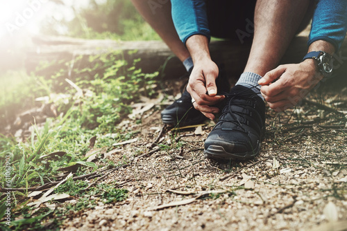 Tying laces, fitness and hands in nature to start walking, adventure or trekking for exercise. Shoes, sports and feet of a man getting ready for cardio, training or a walk for a workout in a park