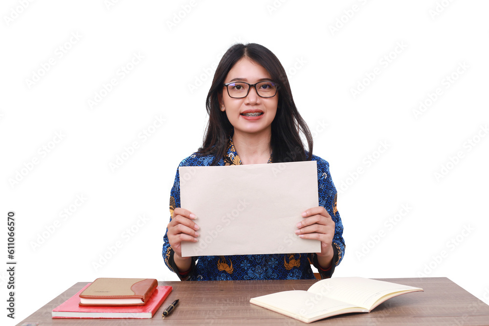 Happy Asian female in batik korpri, indonesian traditional worker uniform showing a blank paper Happy Asian female in batik korpri, indonesian traditional worker uniform showing a blank paper