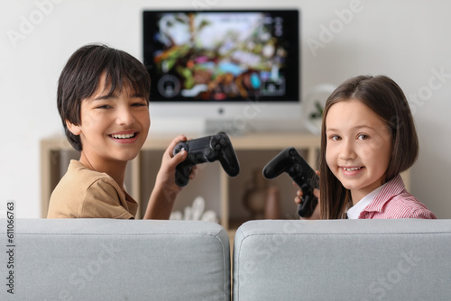 Little children playing video game at home