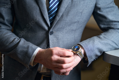 Elegant man with expensive watch on his hand stands reception desk