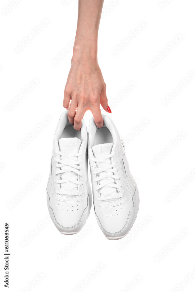 White leather female sneakers in hands isolated on white background. Fashionable stylish sports casual shoes.
