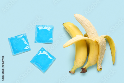 Bananas with condoms on blue background. Sex concept photo