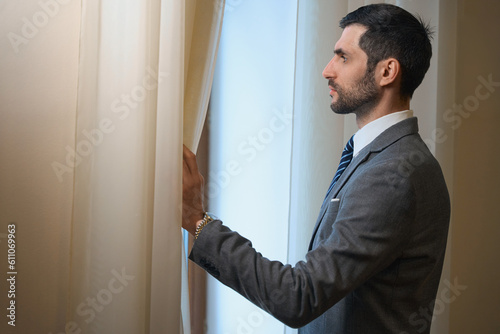 Middle-aged hotel guest stands at the window