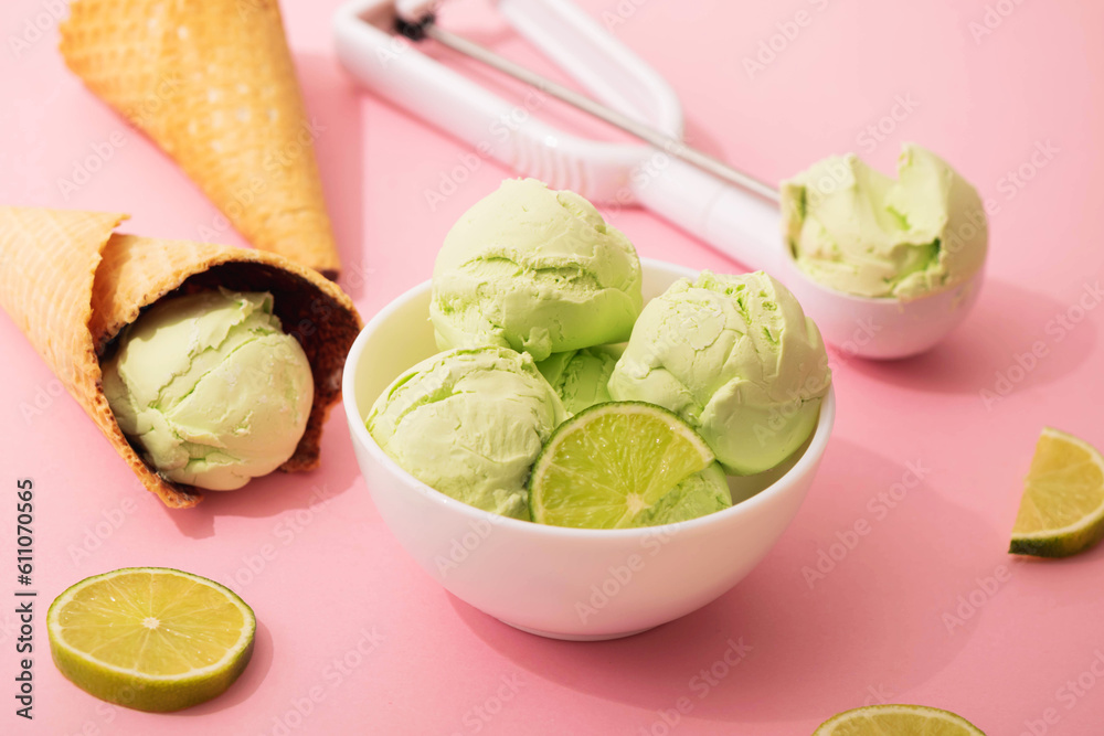 Ice cream with lime flavor in waffle cone and white bowl, pink background with pieces of juicy lime, copy space, flat lay Ice cream with lime flavor in waffle cone and white bowl, pink background with pieces of juicy lime, copy space, flat lay