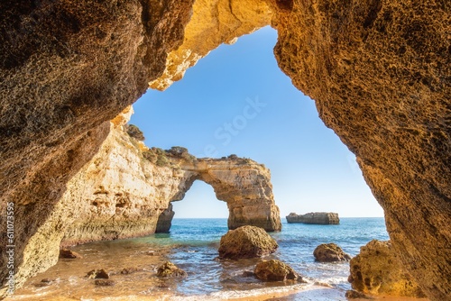 Natural arch above ocean, Algarve, Portugal. View of the natural stone arch during beautiful sunny day. Turism concept