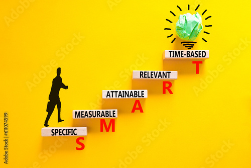 SMART symbol. Concept words SMART specific measurable attainable relevant time-based on block. Beautiful yellow background. Business SMART specific measurable attainable relevant time-based concept. photo