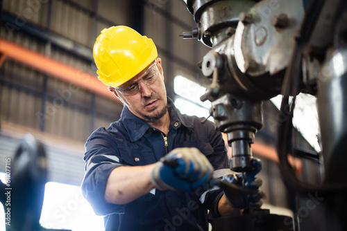 фотографія Professional caucasian white ethnicity male technician operating the heavy duty machine in the lathing factory