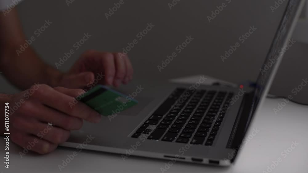 male hands of cardholder holding credit card making e bank online payment. man consumer paying for purchase in web store using laptop technology. Ecommerce website payments concept. Close up view male hands of cardholder holding credit card making e bank online payment. man consumer paying for purchase in web store using laptop technology. Ecommerce website payments concept. Close up view
