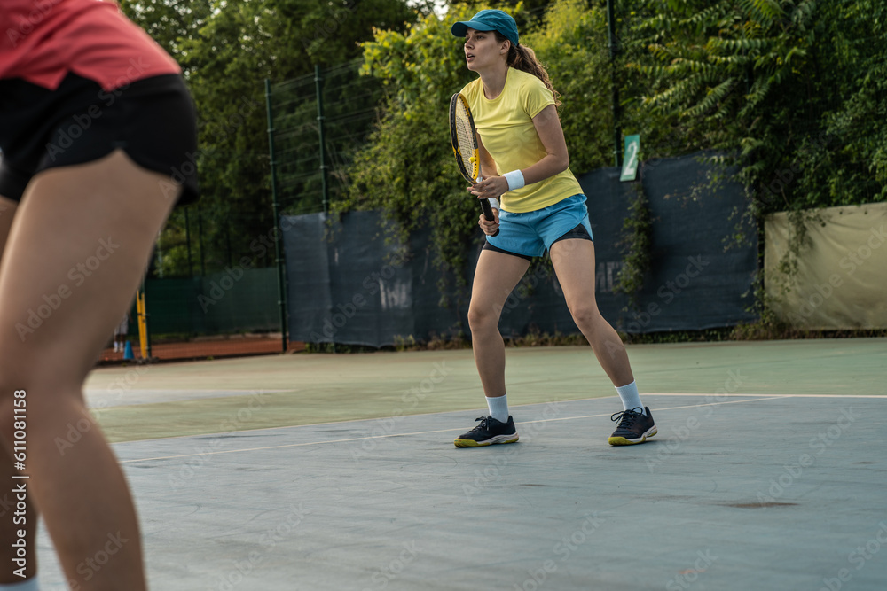 Φωτογραφία Two competitive female tennis players engage in an intense match, their swift movements and powerful strokes showcasing their dedication and love for the sport