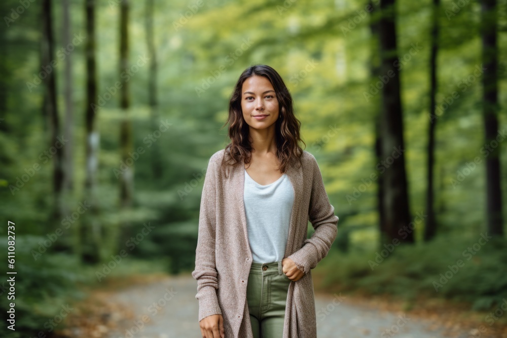 Full-length portrait photography of a satisfied girl in her 30s wearing a chic cardigan against a forest background. With generative AI technology Full-length portrait photography of a satisfied girl in her 30s wearing a chic cardigan against a forest background. With generative AI technology