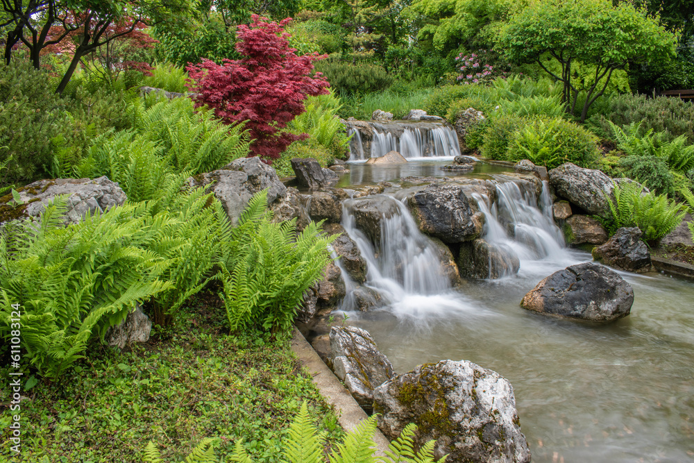 beautiful landscape with waterfall falling from stone wall in japanese style landscape park. Selective focus.