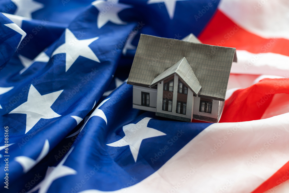 Concept is real estate in the USA. Realtor in the United States. Rental housing in New York. Home for sale in the USA. Layout of the house next to the US flag. Life in the USA. Emigration to America