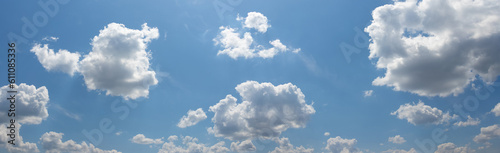 Blue sky with white cumulus clouds illuminated by the sun