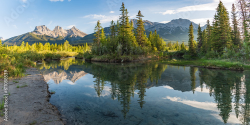 Panoramic view of the Three Sisters in Canmore  near Banff National Park in summer with sunset view over wilderness area panorama.