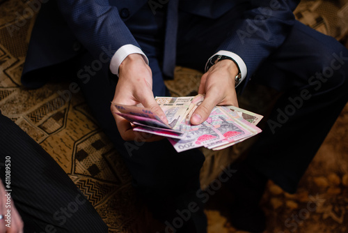 Wallpaper Mural a man or a businessman in a suit counts money at home. Ukrainian money. Torontodigital.ca