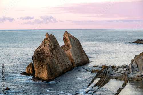 Steep islet in rocky coastline photo