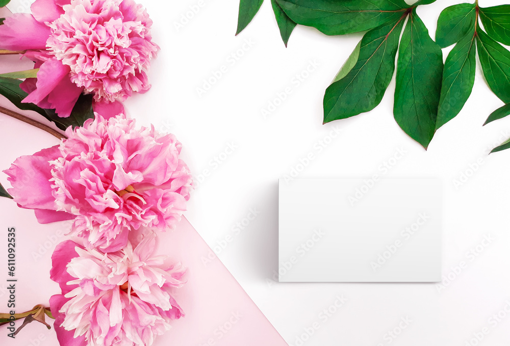 Obraz premium Composition of pink peonies, leaves, blank card on a white and pastel pink background. Fresh flowers. Floral content for Birthday, Valentines Day, Womens day. Flat lay, top view, close up, copy space