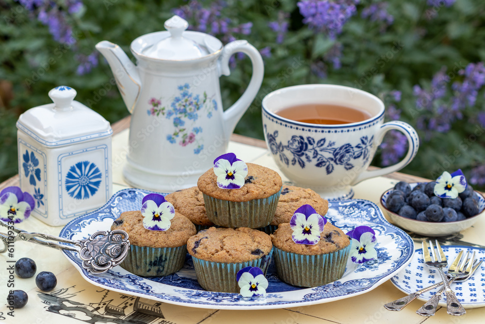 vegane Heidelbeer-Apfel-Muffins auf einem Teller und weiß-blaues Teegeschirr vegane Heidelbeer-Apfel-Muffins auf einem Teller und weiß-blaues Teegeschirr