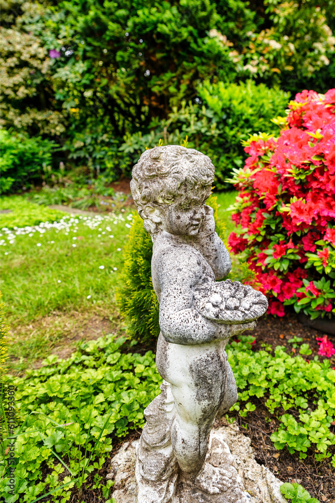 ein Engel steht neben einem blühenden Azaleenstrauch auf einem Friedhof in Ratingen Hösel ein Engel steht neben einem blühenden Azaleenstrauch auf einem Friedhof in Ratingen Hösel